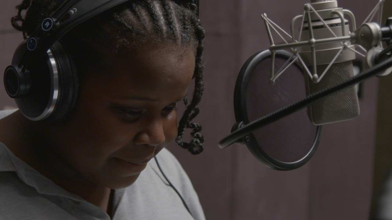 a young girl with headphones by a microphone