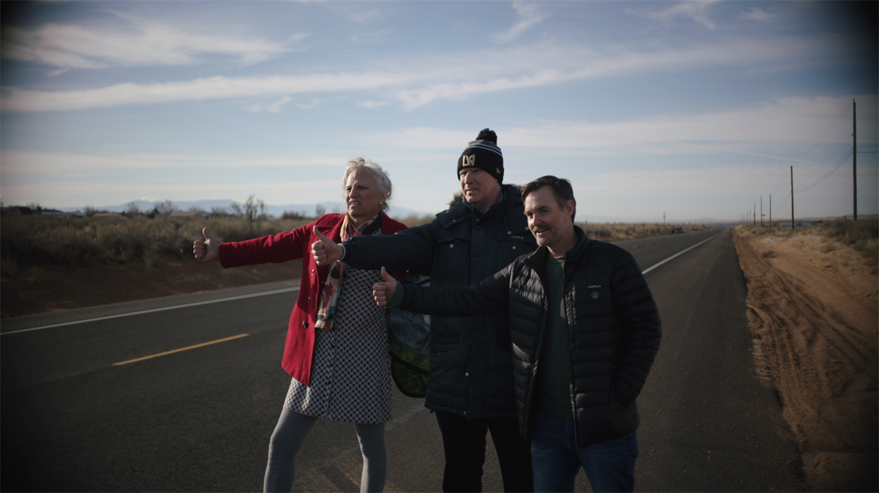 three people hitchhike