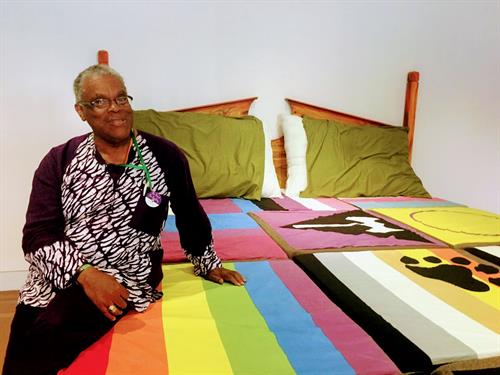 Louis Hughes sitting on Queer Quotidian Bed create